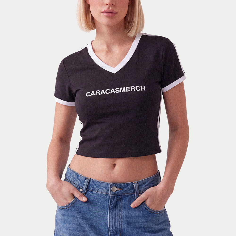 Woman wearing the black Caracasmerch soccer crop tee with blue jeans